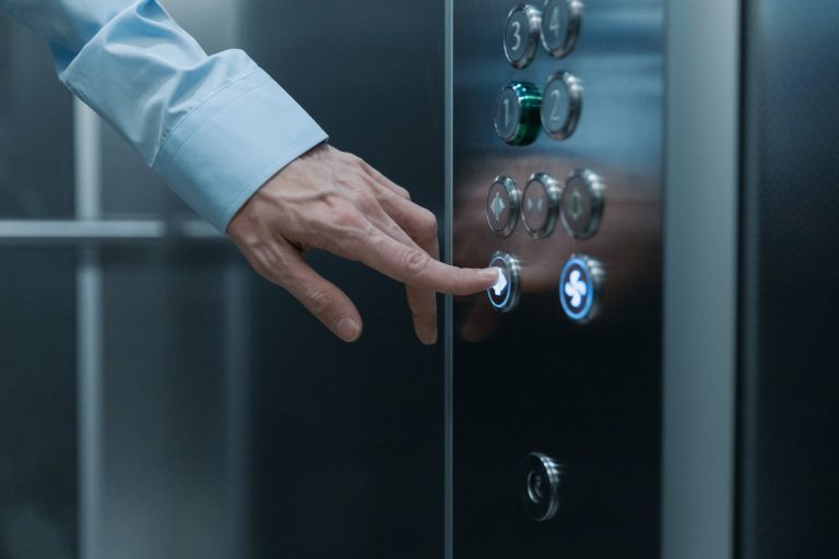 close up shot of a hand pressing an elevator button