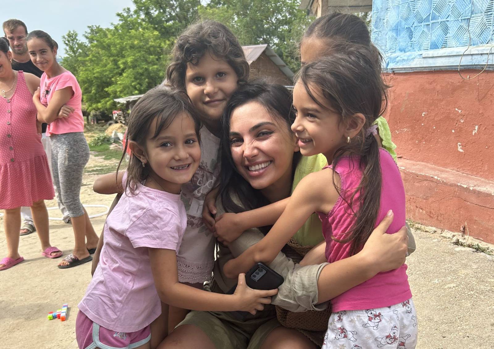 Andra Munteanu inconjurata de copiii din comunitati